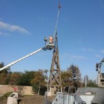 A worker prepares the windmill tower for removal.