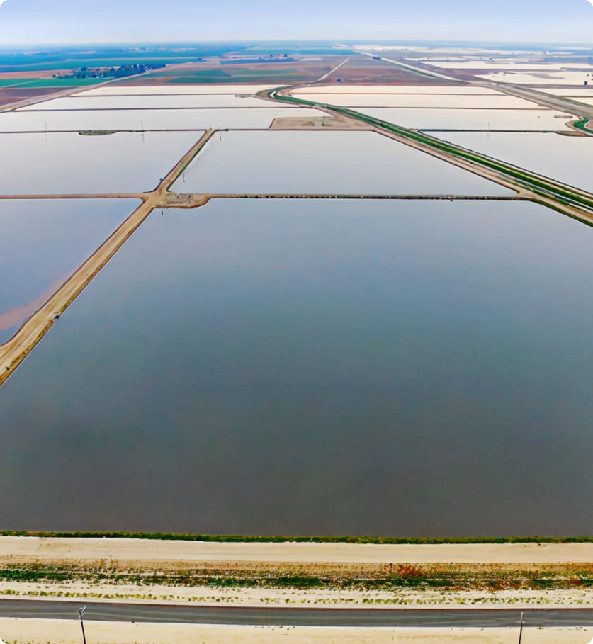Aerial view of rectangular salt ponds separated by dirt embankments and roads.