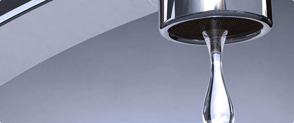 Close-up of a polished chrome faucet with a single water droplet forming on the spout.