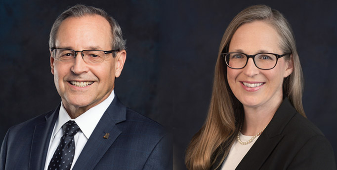 Portrait of a man and a woman in business attire wearing glasses.