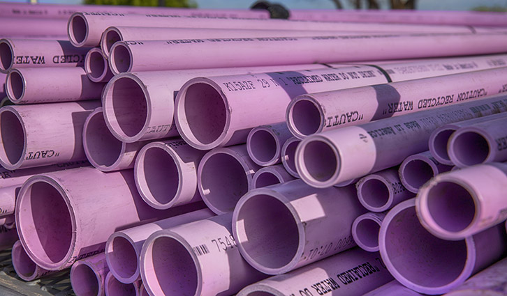 Stacked pink PVC pipes with printed markings