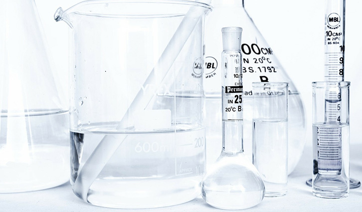 Collection of lab glassware including beaker, Erlenmeyer, and test tubes on a lab bench.