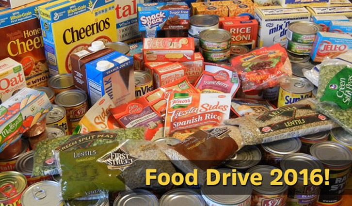 Pile of assorted canned goods and boxed foods for a food drive, with a banner reading Food Drive 2016.