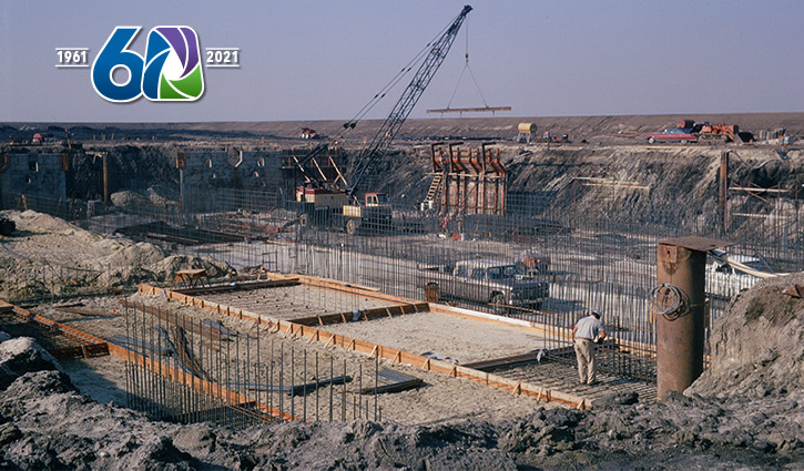 Construction site with reinforced concrete formwork, wooden frames, and a crane over a large excavation.