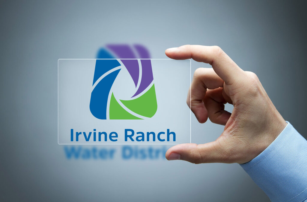 Hand holding a transparent card displaying the Irvine Ranch Water District logo.